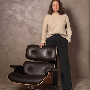 Professionele foto van Lotte Zunneberg zittend op een zwarte designstoel in een moderne ruimte