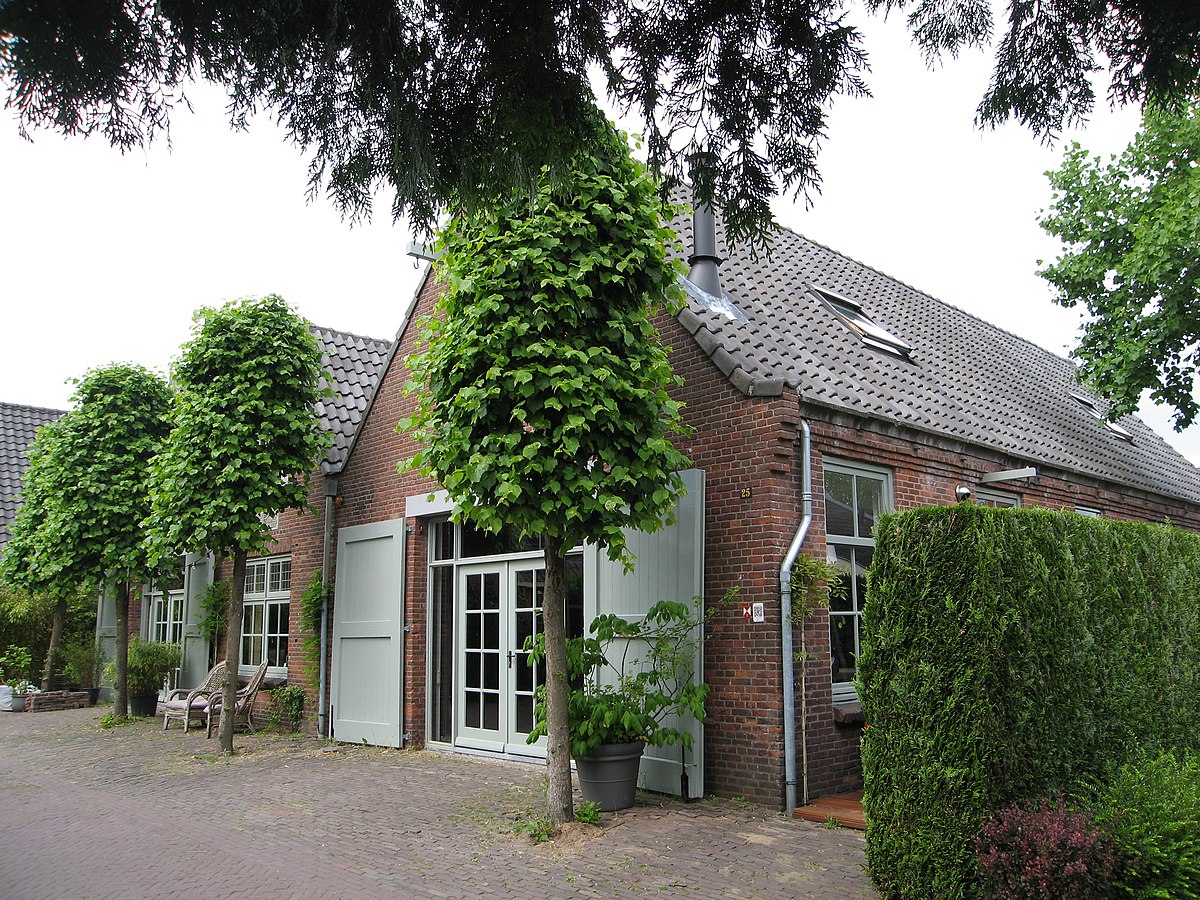Lichte slaapkamer in woonhuis Huizen met wit bed en grote ramen